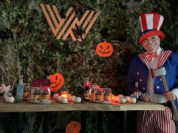 Man dressed like Uncle Sam standing next to table with sweets